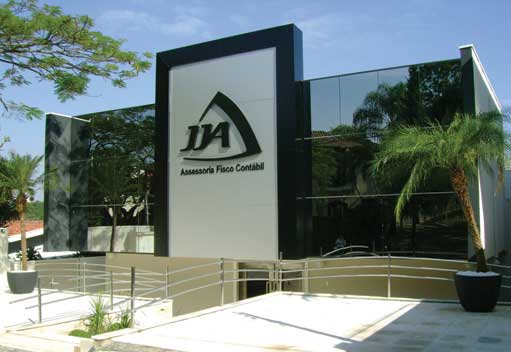 A fachada da edificação com painéis de vidro e placas metálicas onde foi colocado o logotipo