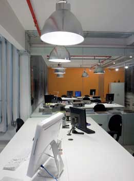 As mesas e estações de trabalho e todos os ambientes receberam uma luminária de tipo industrial